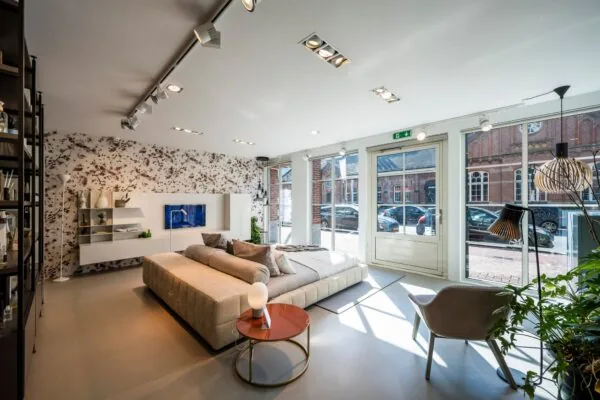 Modern ingerichte woonruimte met een bed, designmeubilair en grote ramen aan de Oostelijke Handelskade.